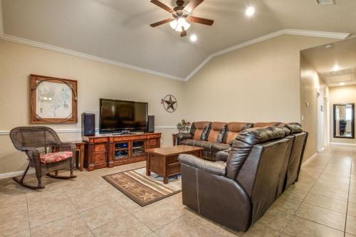 een woonkamer met een bank en een flatscreen-tv bij River View on the Guadalupe - Riverfront with Large Deck & Cliff Side Views in New Braunfels