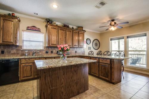 een grote keuken met houten kasten en een aanrecht bij River View on the Guadalupe - Riverfront with Large Deck & Cliff Side Views in New Braunfels