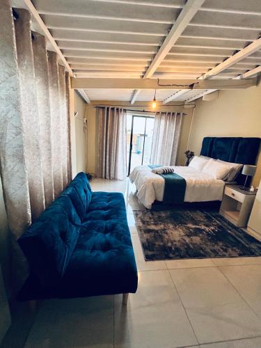 a bedroom with a bed and a couch in a room at Enez Place in Gqeberha