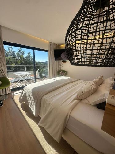 a bedroom with a large bed and a large window at Tiny house in São Brás de Alportel