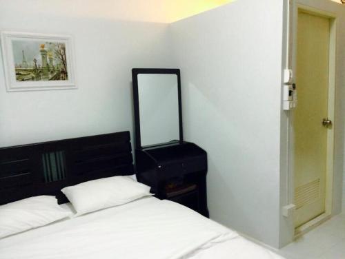 a bedroom with a bed and a mirror on the wall at Bann Bunga Inn in Bangkok