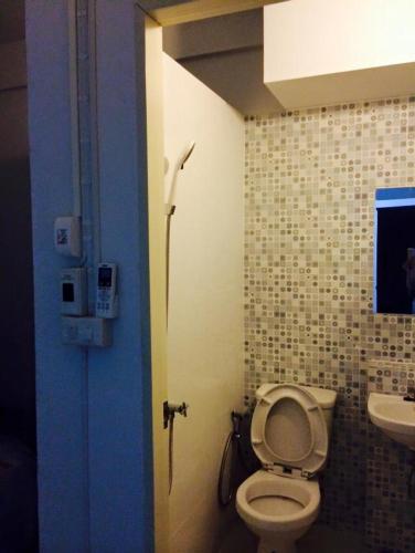 a bathroom with a toilet and a sink at Bann Bunga Inn in Bangkok