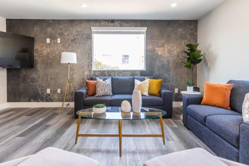 Hollywood Burbank AirportにあるModern 4BR Stay Premium Beds & Full Kitchenの青いソファとテーブルのあるリビングルーム