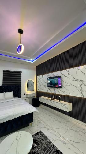 a bedroom with a bed and a tv on a wall at The White Residence, Jabi, Abuja in Abuja