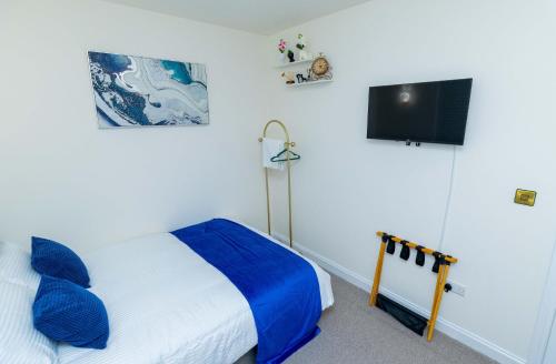 a bedroom with a bed and a flat screen tv at Paradise Nestv in Manchester