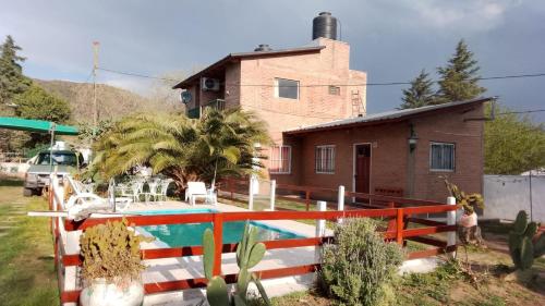 ein Haus mit einem Pool vor einem Haus in der Unterkunft Complejo "El Padrino" in Villa Carlos Paz