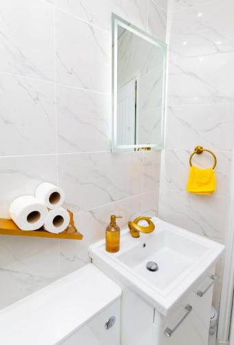 a white bathroom with a sink and a mirror at Paradise Nestv in Manchester