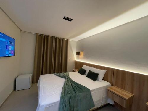a hotel room with a bed and a television at Pousada Na Serra in Ubajara