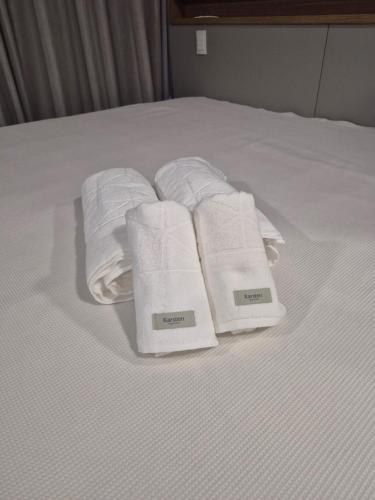 a group of towels sitting on top of a bed at STÚDIO 017 - Novo e Sofisticado! in Sao Jose do Rio Preto