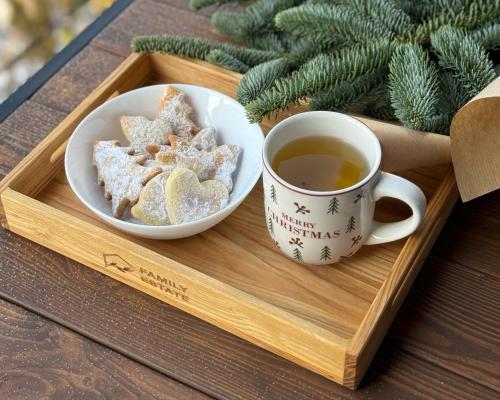 a tray with a cup of tea and a bowl of cookies at BarnHouse "Family Estate" in Kamianets-Podilskyi