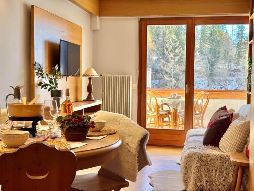 a living room with a table and a living room with a patio at Lac & Love - Alpine Escape in Crans-Montana