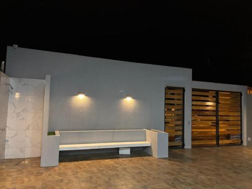 a bench in a room with wooden doors and a wall at Alojamiento en Ayangue in Santa Elena