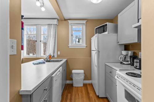 een keuken met witte apparatuur en een witte koelkast bij Midstream Executive 2BR Wi-Fi Parking in St. John's