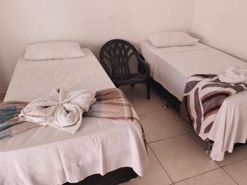 a room with two beds with towels on them at Fonte dos Corais - Suíte Onda do Mar in Maragogi