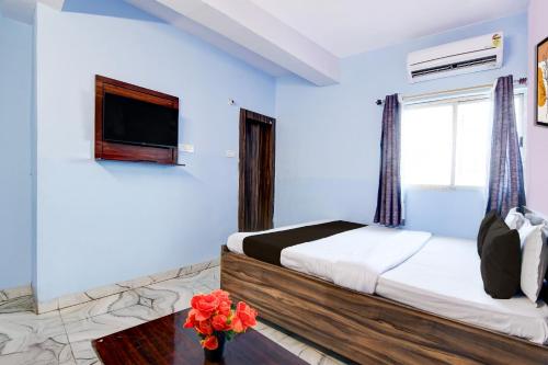 een slaapkamer met een bed en een tv aan de muur bij Hotel O Deendayal Crossway Ranchi Formerly Yashoda in Rānchī