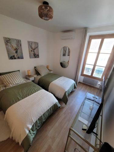 a bedroom with two beds and a mirror at Echappée verte avec piscine et clim proche de Paris in Vert-le-Grand