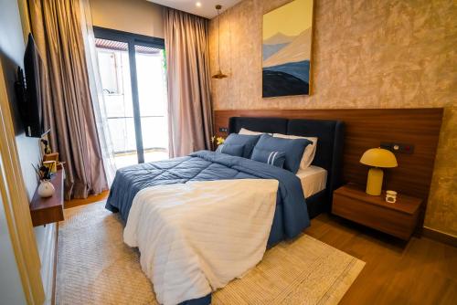 a bedroom with a bed with a blue comforter at Résidence LOBOS in Dakar