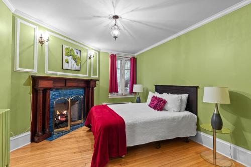 een groene slaapkamer met een bed en een open haard bij Midstream Flat 2BR Wi-Fi Parking in St. John's