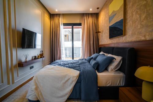 a bedroom with a bed with blue sheets and a window at Résidence LOBOS in Dakar