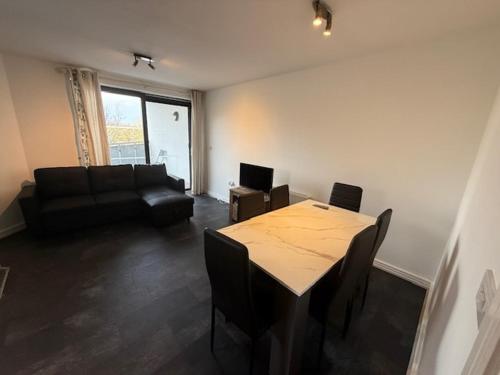 a living room with a table and a couch at Modern flat in Abbey Wood in Abbey Wood