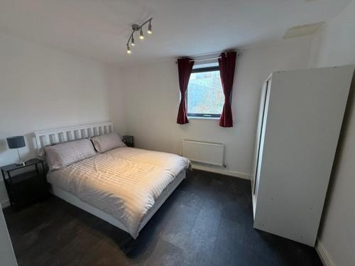 een kleine slaapkamer met een bed en een raam bij Modern flat in Abbey Wood in Abbey Wood