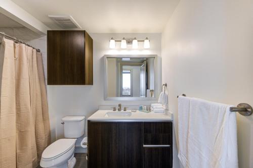 een badkamer met een wastafel, een toilet en een spiegel bij Hanover River Oaks in Houston