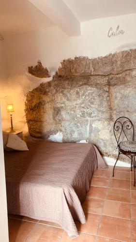 una camera da letto con un letto in un muro di pietra di Medieval Studio St Eloi a Le Castellet