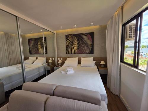 a bedroom with two beds and a couch at Luxurious Flat at Lake Side with lake view. in Brasília