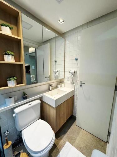 a bathroom with a toilet and a sink and a mirror at Luxurious Flat at Lake Side with lake view. in Brasília