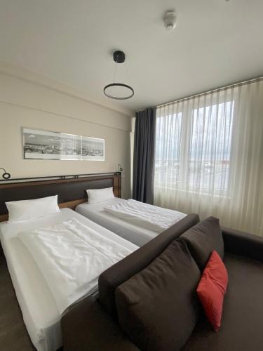 a hotel room with two beds and a couch at Motel Plus Schönefeld in Schönefeld