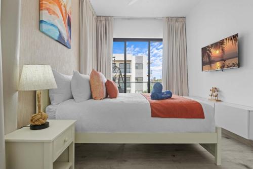 a bedroom with a bed with a teddy bear on it at NOK Elegant 2BR Apt by Vistacana in Punta Cana