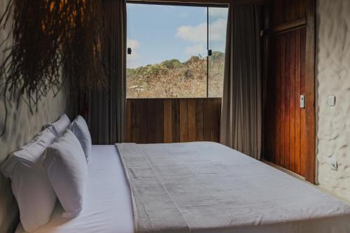 una camera da letto con un letto grande con una finestra di Villa Milos a Fernando de Noronha