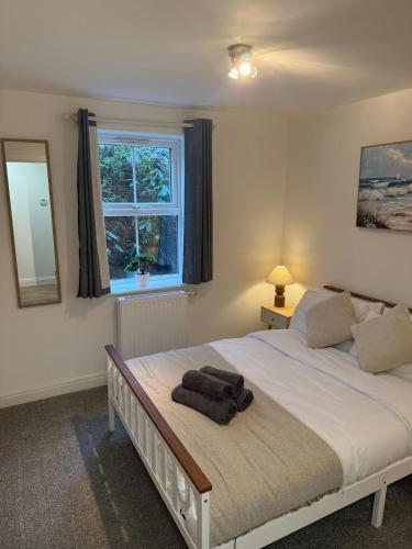 a bedroom with a bed with a mirror and a window at Relaxing Coastal Flat, Perfect Location in Southbourne