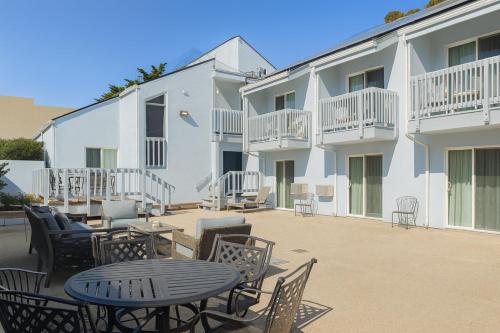 a patio with a table and chairs in front of a building at Cannery Row Inn in Monterey