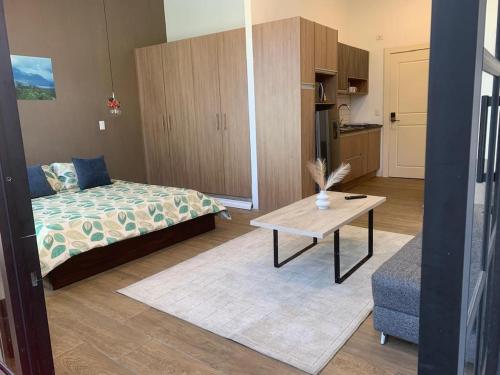 キトにあるSunlight Cumbayaの部屋にベッドとテーブルがある寝室