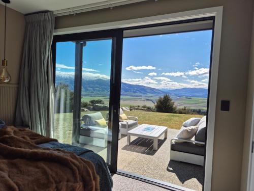 a bedroom with a sliding glass door to a patio at Bendigo Ridge - Where Activity is Relaxing in Cromwell