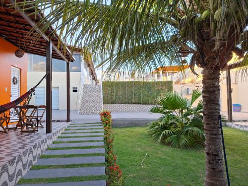 Meu Xodó Pousada في ببرانا: شجرة نخيل بجوار شرفة بها أرجوحة