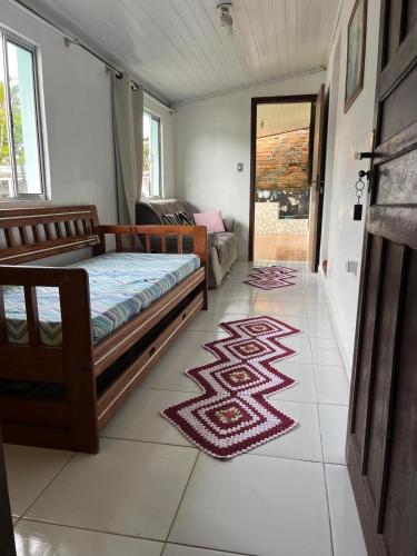 Casa 50 metros da praia mansa في بونتال دو بارانا: غرفة نوم مع سرير وسجادة على الأرض