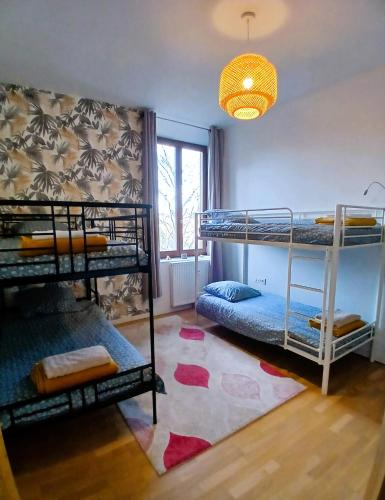 a room with three bunk beds and a window at T4 en duplex, résidence atypique en pleine forêt in Yzeron