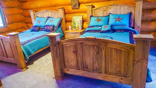 twee bedden in een blokhutslaapkamer bij Blue River Inn. Com in Tishomingo