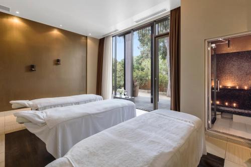 two beds in a room with a fireplace at Lancemore Mansion Hotel Werribee Park in Werribee