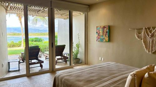 a bedroom with a bed and a view of the ocean at Dream Villa in Majahua in La Majahua