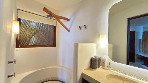 a bathroom with a tub and a sink and a mirror at Dream Villa in Majahua in La Majahua