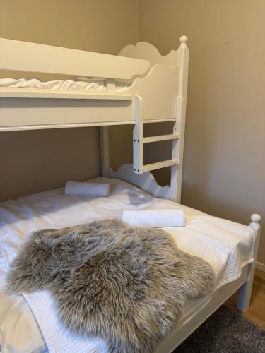 a white bunk bed with a furry blanket on it at 3 min til Skibakken - WiFi - Parkering - Varme in Vossevangen