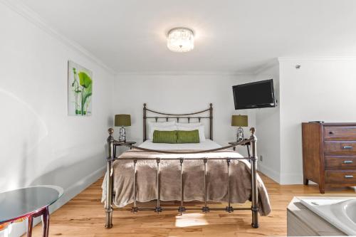 Downtown Gem 2BR Tub Parking في سانت جون: غرفة نوم بسرير وطاولة وتلفزيون
