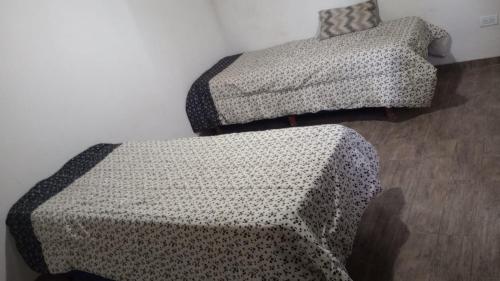 een kamer met 2 bedden en een bank en een stoel bij Complejo Picota III in Mar de Ajó