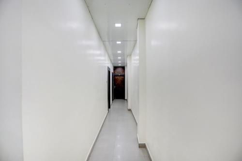 a hallway in an office building with white walls at Hotel O Shad Residency in Patna