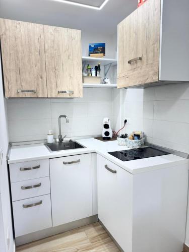 Dream في تروبيا: مطبخ أبيض مع دواليب بيضاء ومغسلة