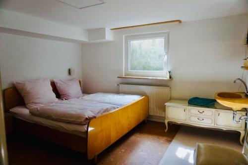 une petite chambre avec un lit et un lavabo dans l'établissement Cozy house with courtyard, à Munich