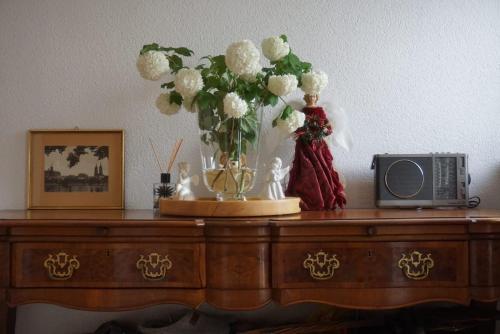 une table avec un vase de fleurs et une télévision dans l'établissement Cozy house with courtyard, à Munich